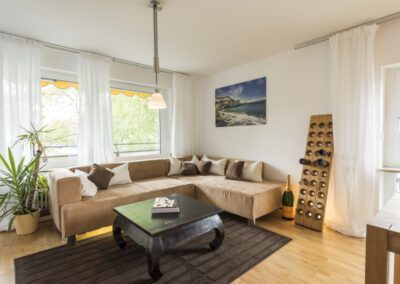 Immobilienfotograf München – Gemütliches Wohnzimmer mit Sofa und Pflanzen