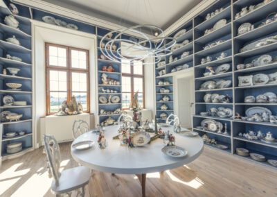 Immobilienfotograf München – Bibliothek mit Porzellan und rundem Esstisch