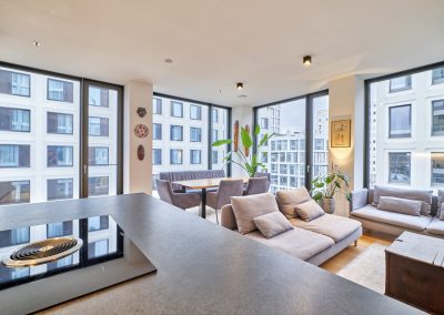 Immobilienfotograf München – Wohnbereich mit Sofa, Essbereich und Panoramafenstern