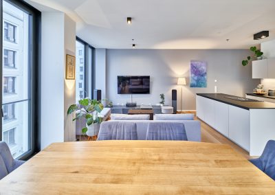 Immobilienfotograf München – Essbereich mit Holztisch, Wohnzimmer und offener Küche