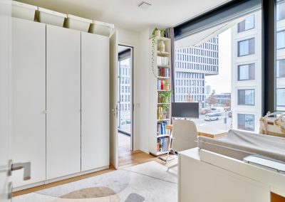 Immobilienfotograf München – Heller Raum mit Kleiderschrank, Bücherregal und Schreibtisch