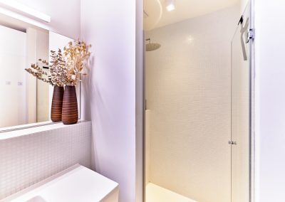 Immobilienfotograf München – Minimalistisches Badezimmer mit Regendusche und dekorativen Akzenten