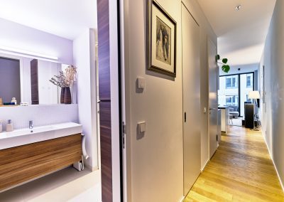 Immobilienfotograf München – Flur mit Blick ins Badezimmer und hellem Holzboden