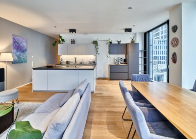 Immobilienfotograf München – Moderner Essbereich mit Holztisch und offener Küche